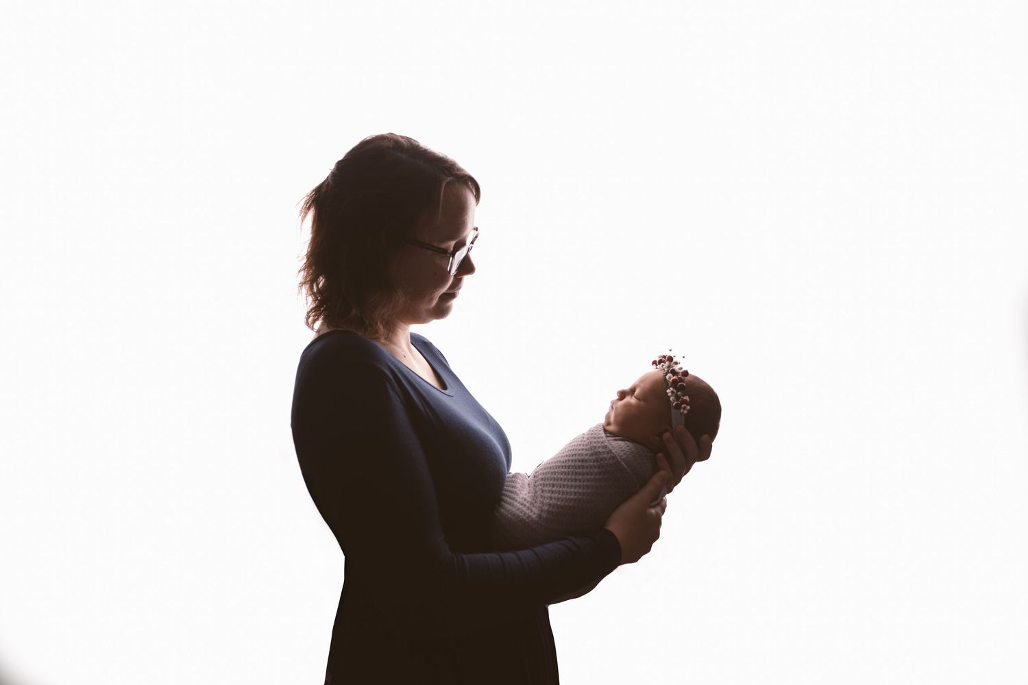 Backlit studio portraits showing tender family interactions.