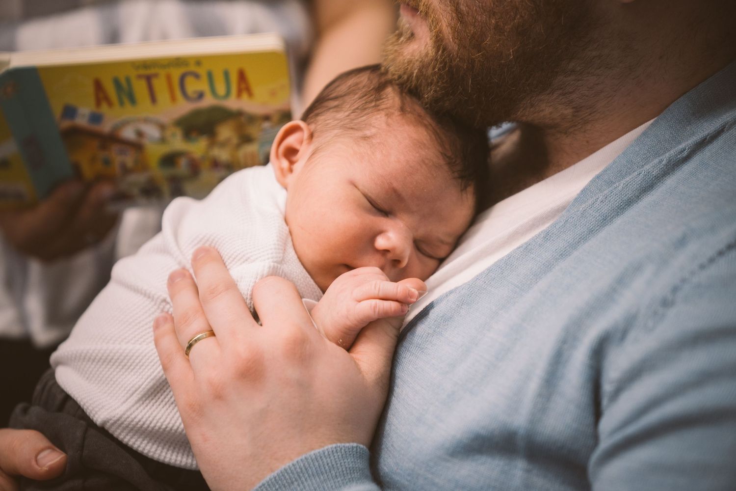 A tender moment between parents and their newborn baby in soft lighting.