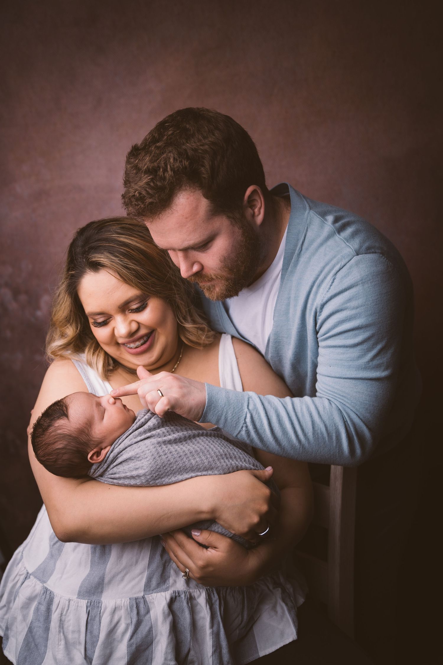 Intimate family portrait session with newborn in studio lighting.
