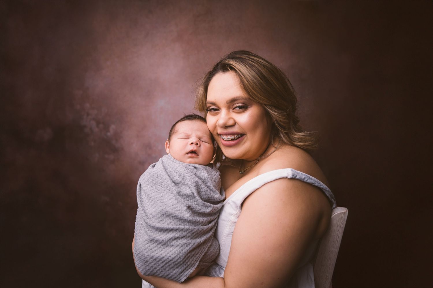Tender family moment with newborn captured in studio lighting.