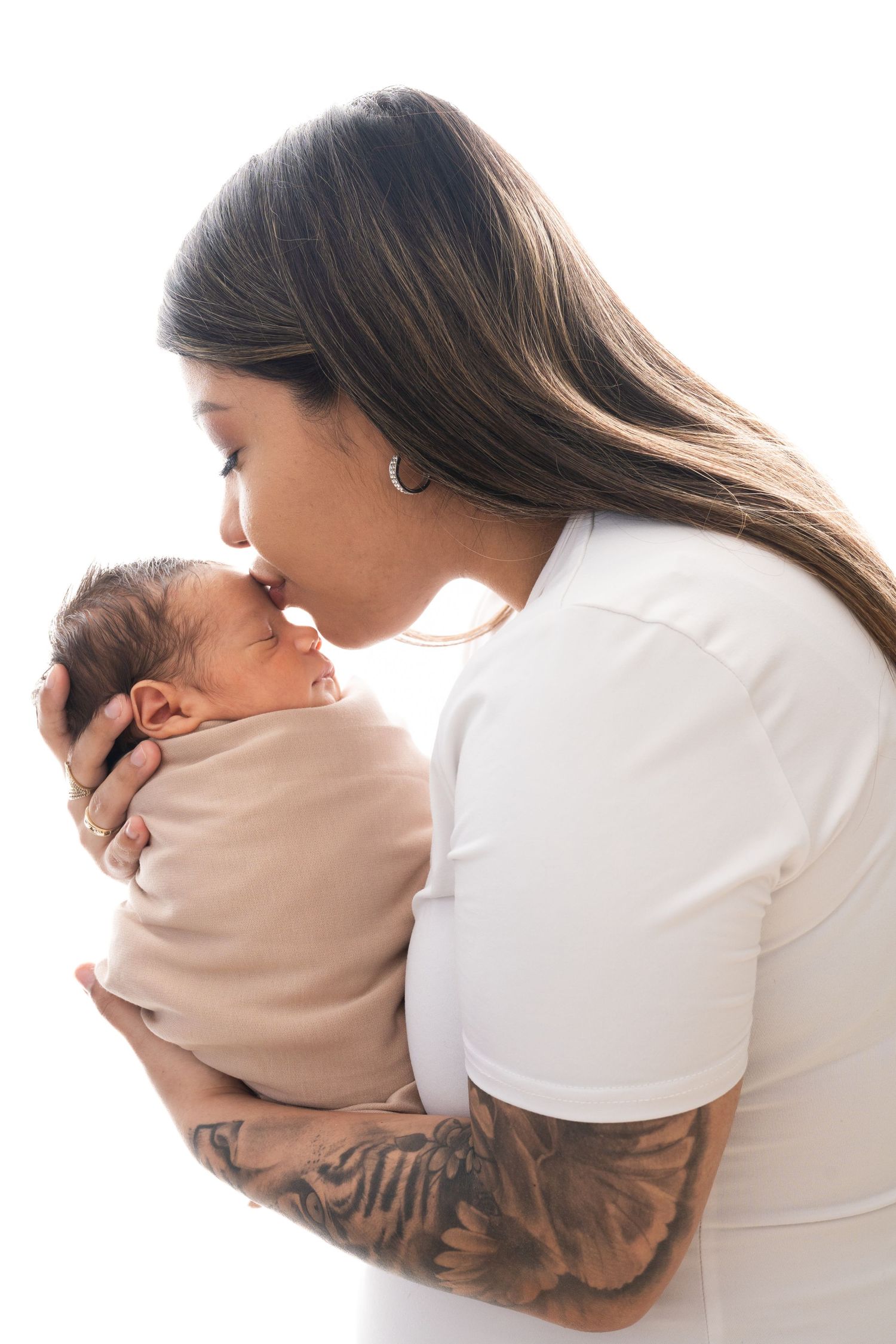 Series of gentle newborn photography poses with parent in white against neutral background.