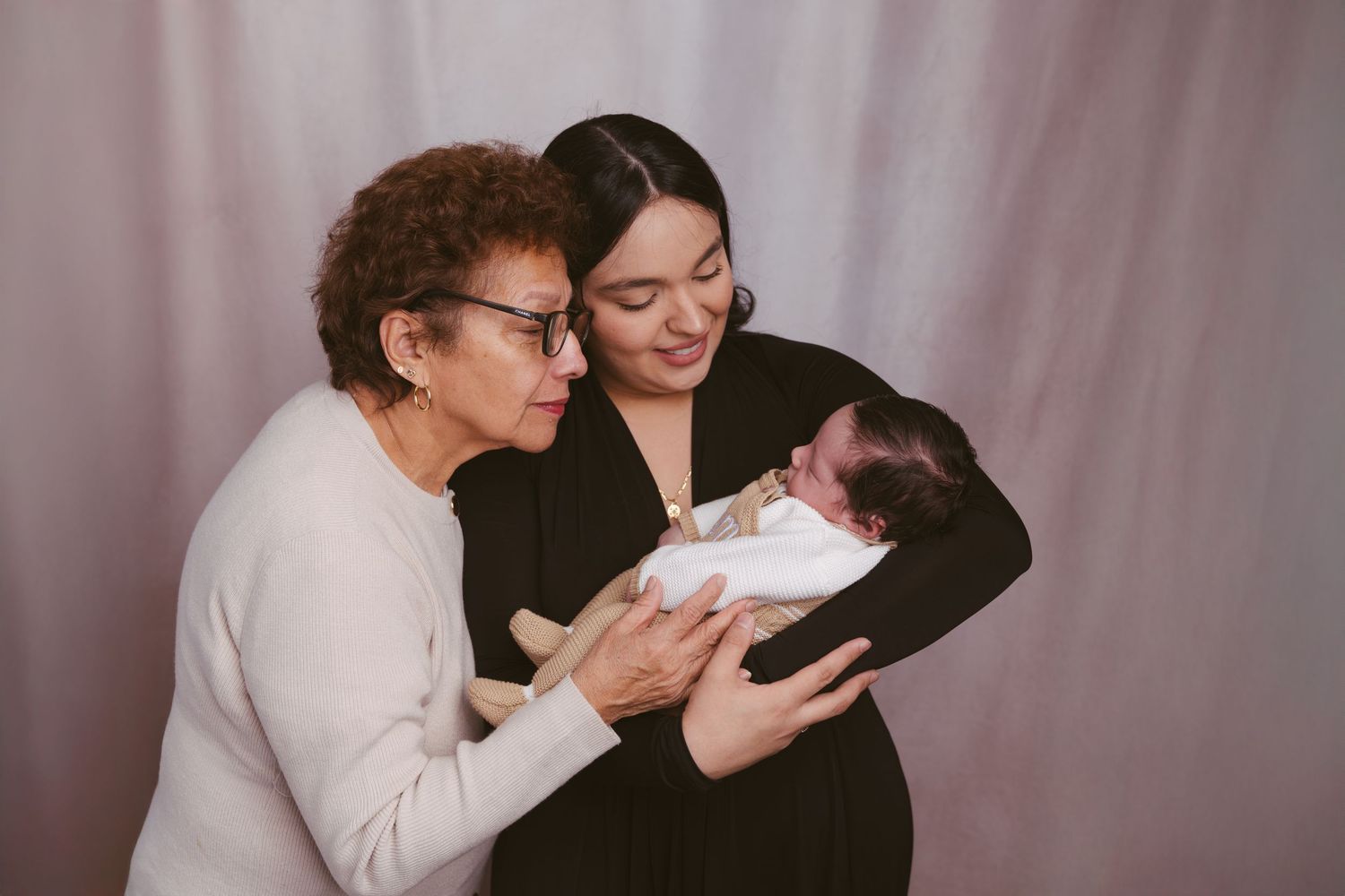 Intimate family portrait series showing tender moments between generations in a studio setting.