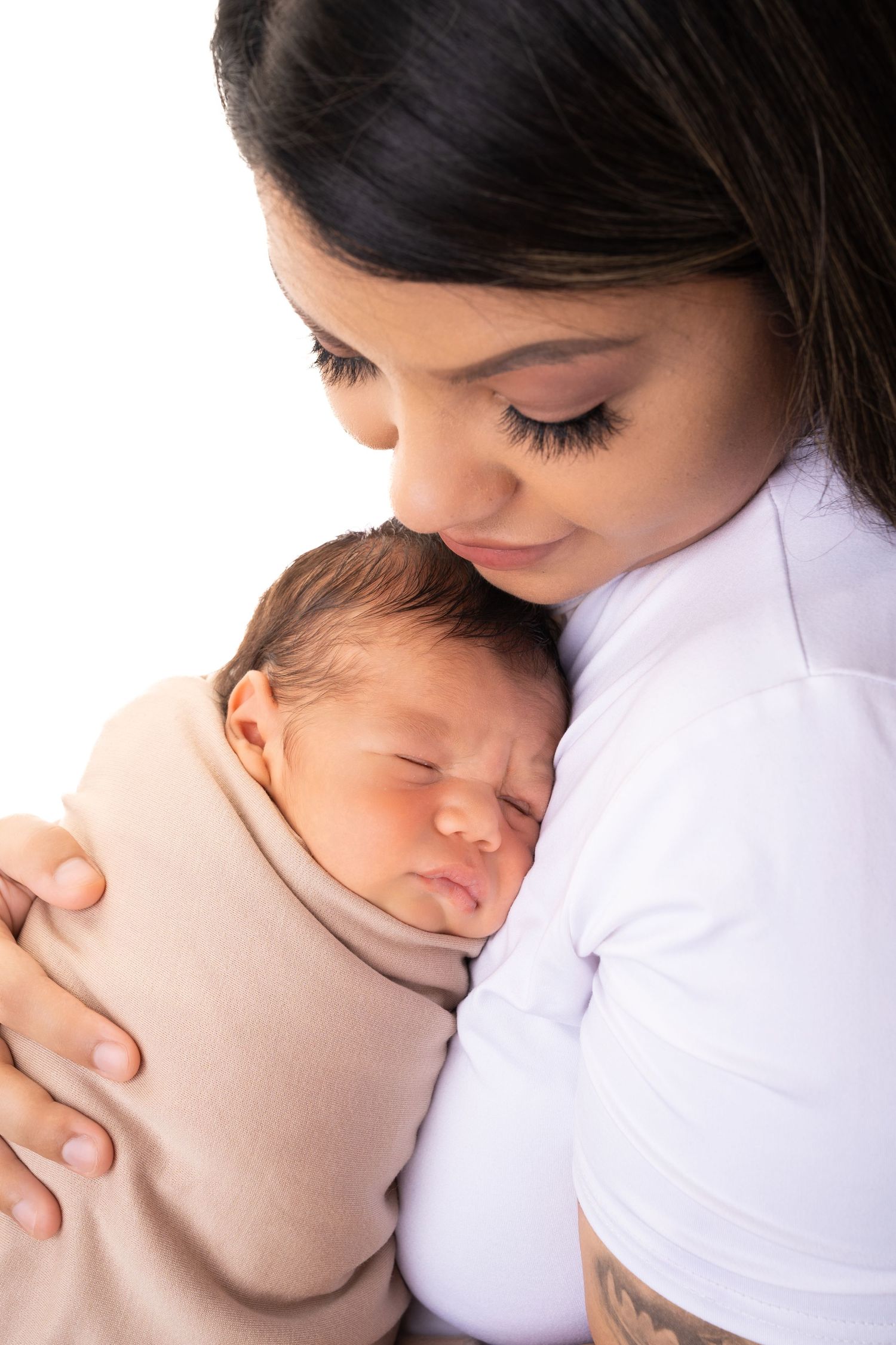 Close-up shots of tender moments between parent and sleeping newborn.