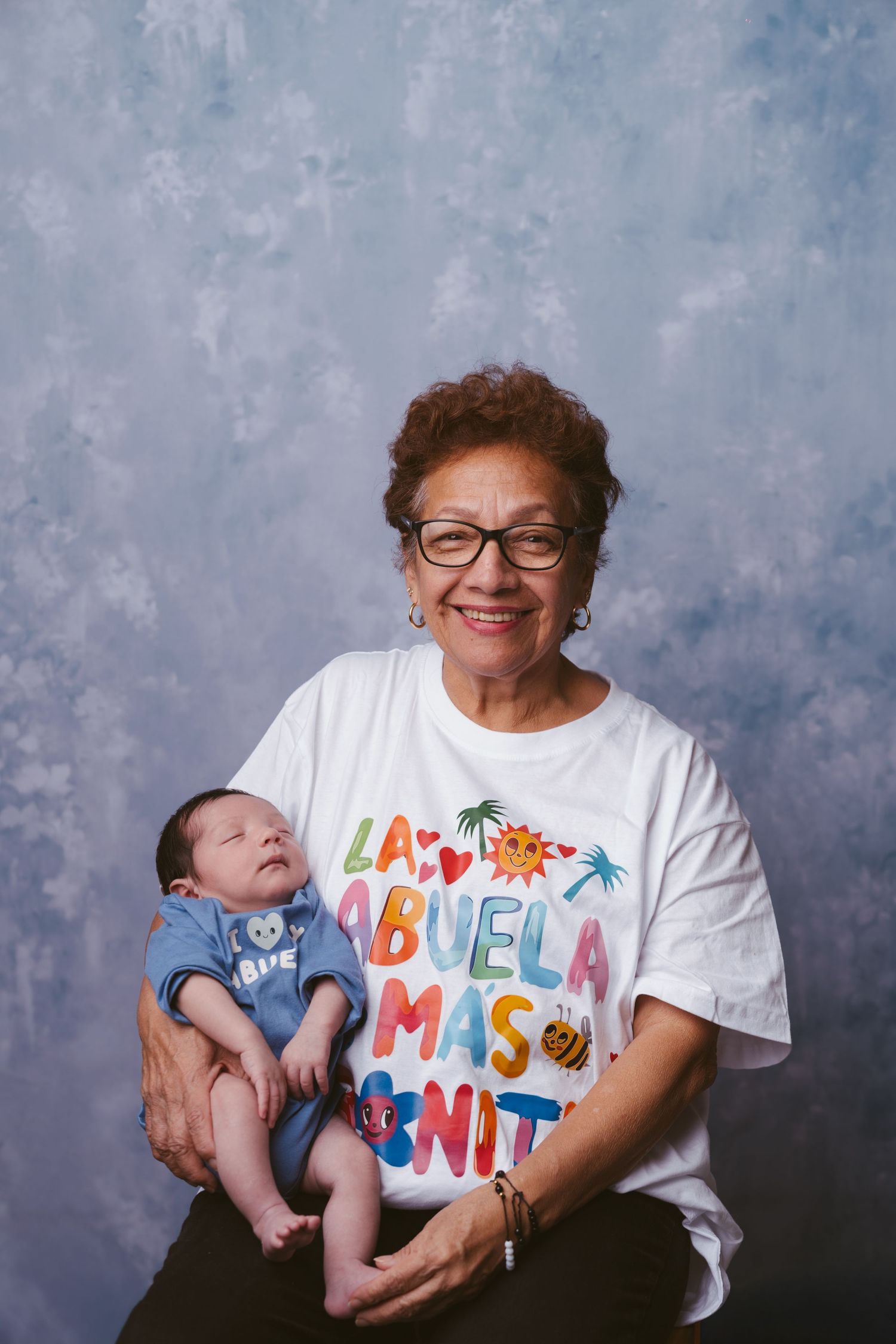 A series of studio portraits showing a baby and someone wearing a colorful t-shirt with text against a gray backdrop.