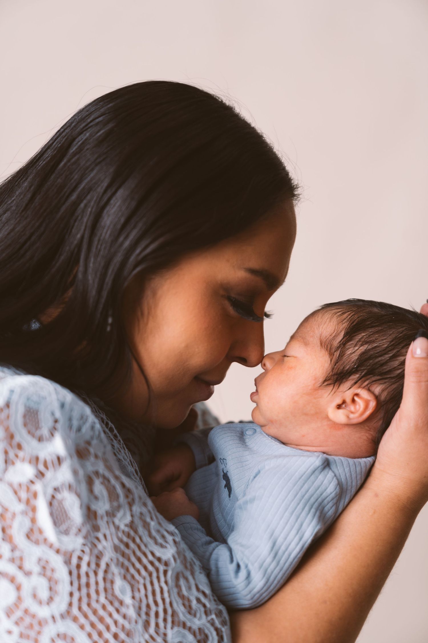 Intimate portrait showing loving interaction with a sleeping baby in blue clothing.
