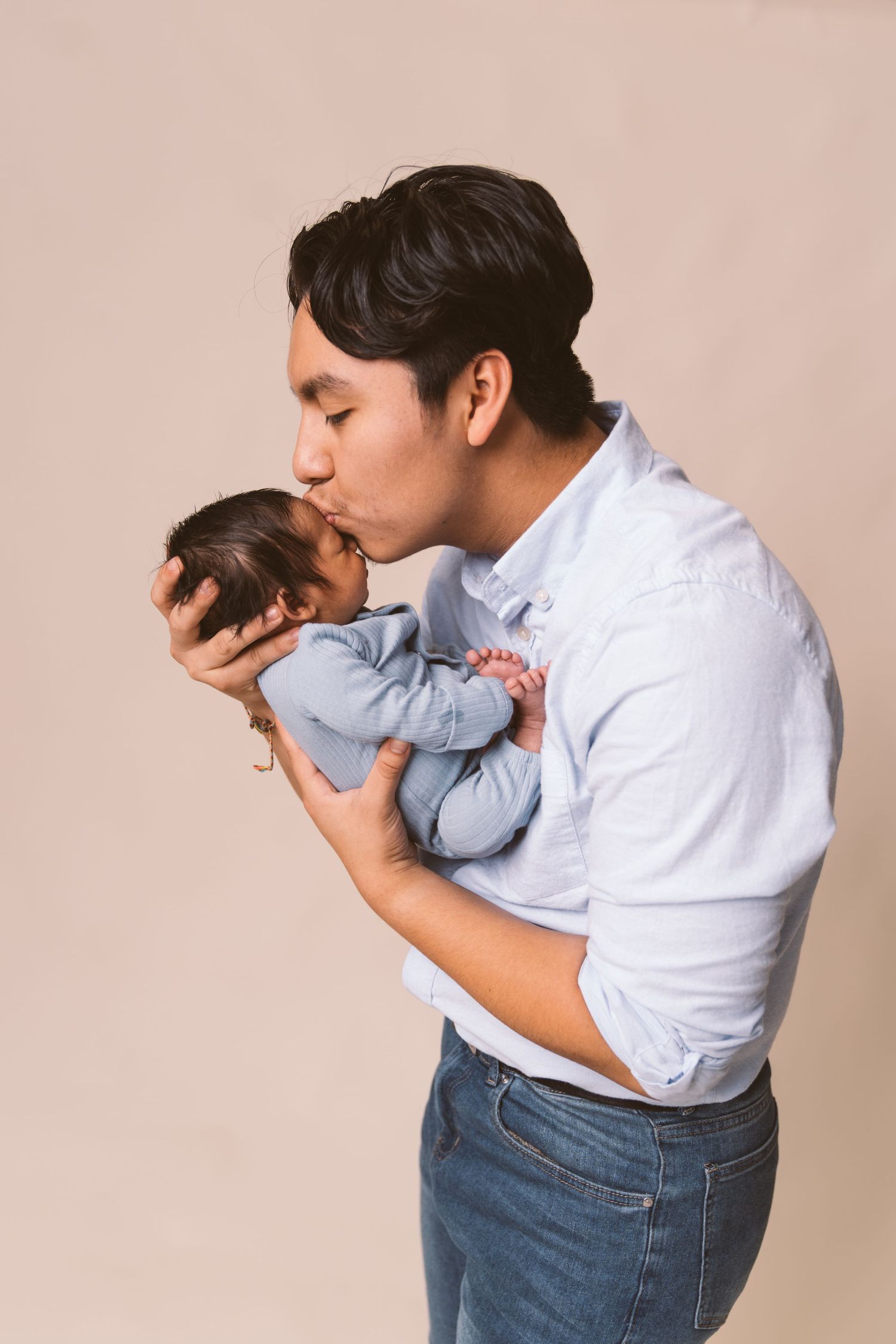 Emotional series showing gentle interaction with sleeping infant in blue clothing.