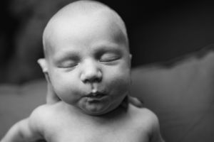 A peaceful black and white portrait of a sleeping newborn.