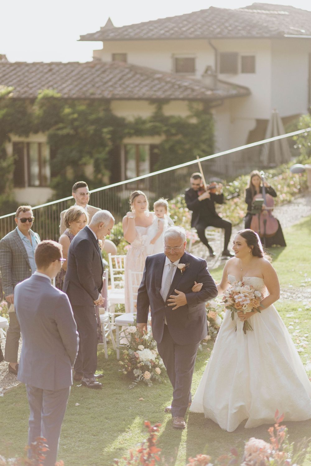 Bride and groom embracing in the gardens of Villa San Michele, Florence, surrounded by autumn light.