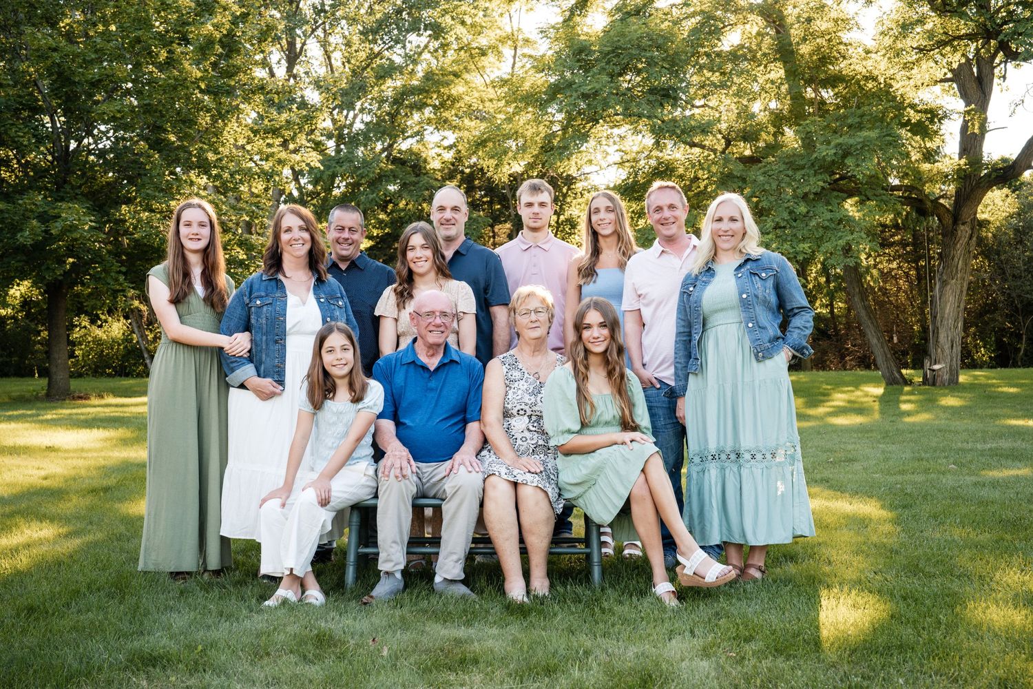 Photo of an extended family posing with a bench at a park taken by Milwaukee family photographer Rachel Dickman.