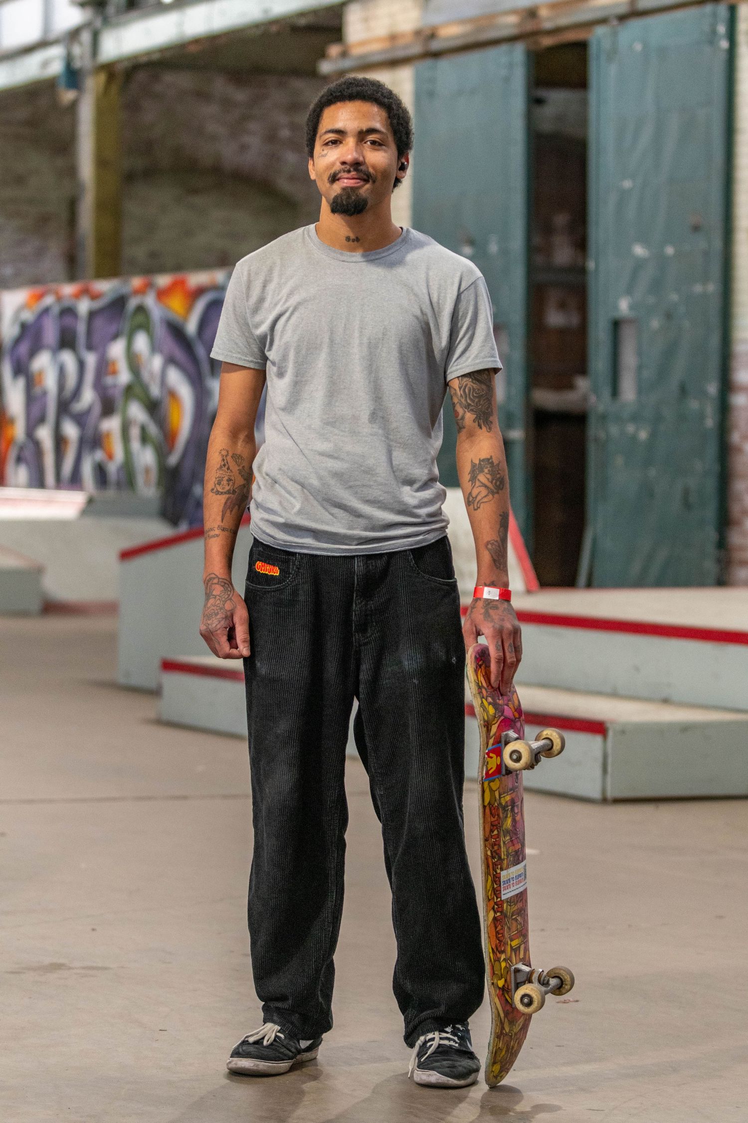 A man posing with his skateboard.
