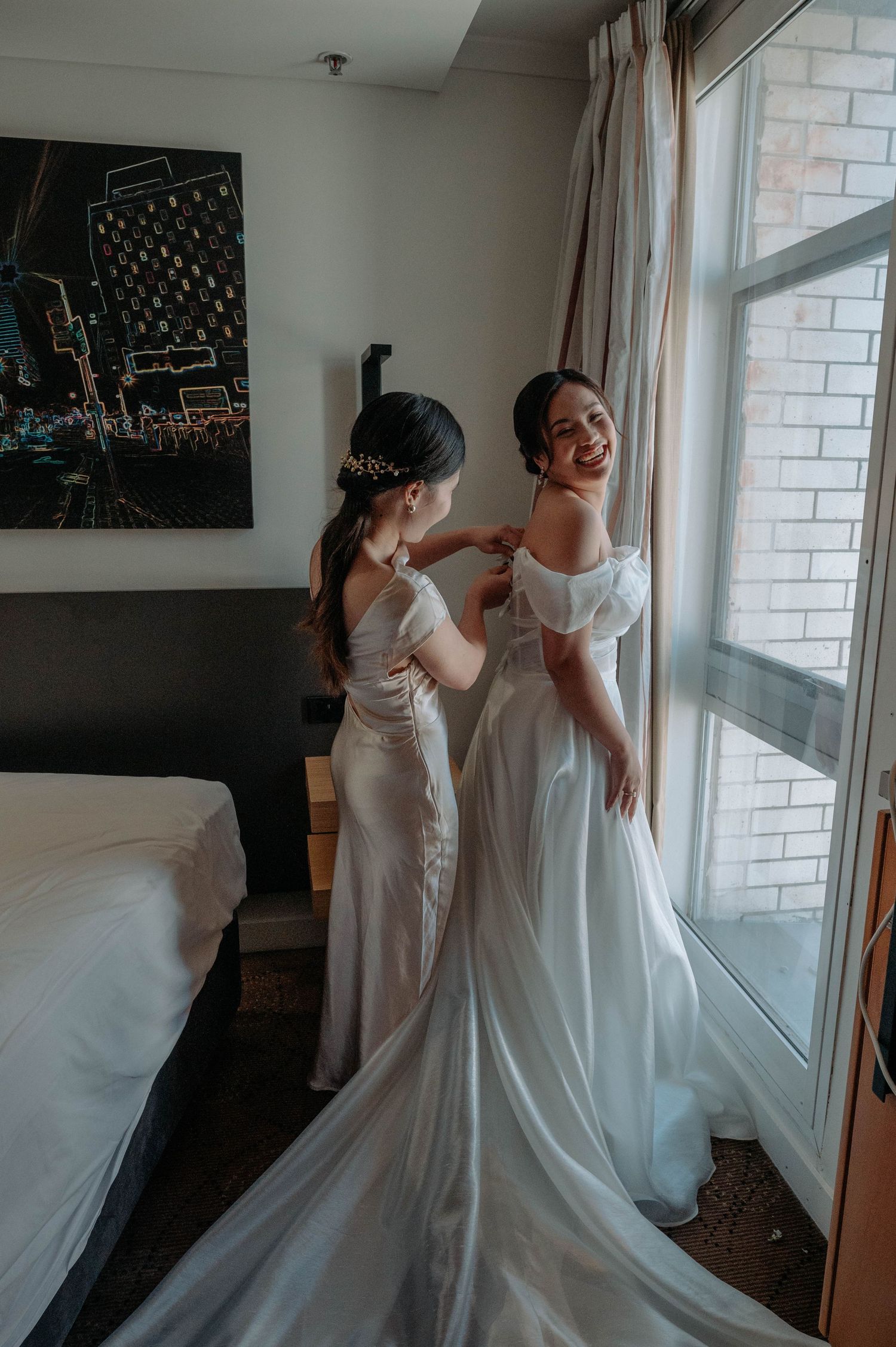 A wedding dress fitting moment captured by a window in natural light.