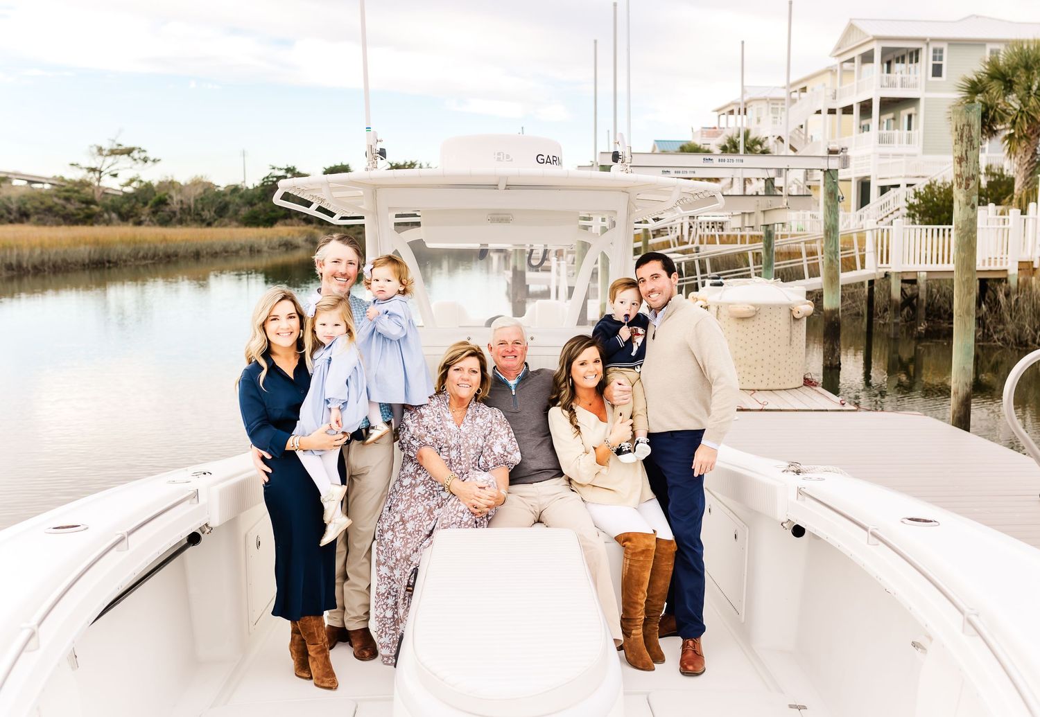 Group gathered on a coastal dock for photos with boats in the background. PRESLEY ROSE PHOTOGRAPHY OCEAN ISLE BEACH SUNSET BEACH HOLDEN OKI