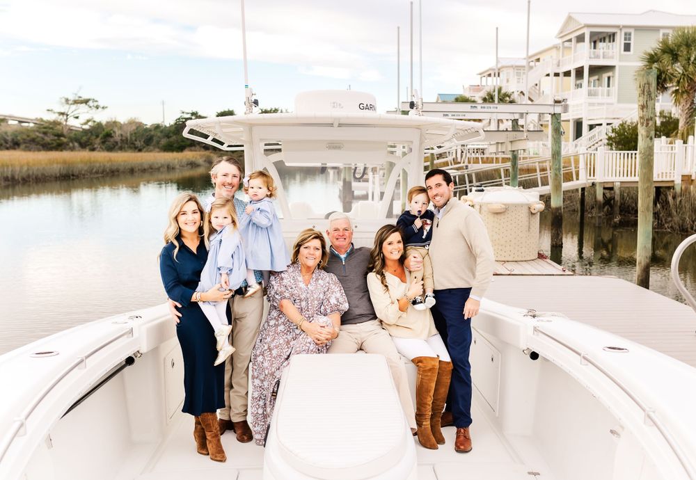 Group gathered on a coastal dock for photos with boats in the background. PRESLEY ROSE PHOTOGRAPHY OCEAN ISLE BEACH SUNSET BEACH HOLDEN OKI