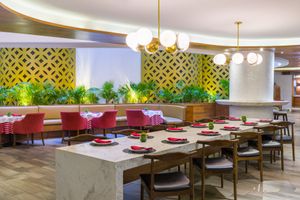 Modern restaurant interior with geometric wall patterns, marble tables, and pink booth seating. Fontana at Barcelo Mexico Reforma.