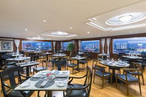 Sophisticated restaurant interior with panoramic windows and elegant place settings. Premium Level Reforma.