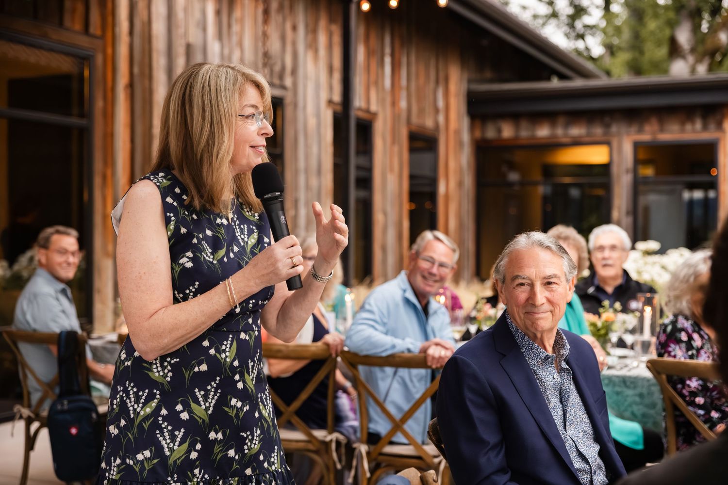 Outdoor reception at rustic venue with guests enjoying celebration.