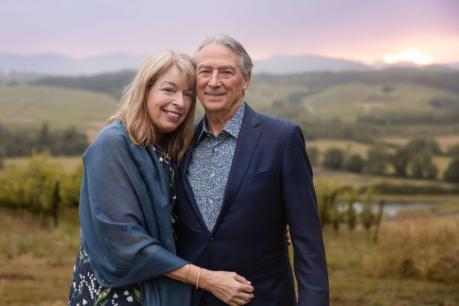 Romantic sunset portrait against rolling hills and mountains in the distance.