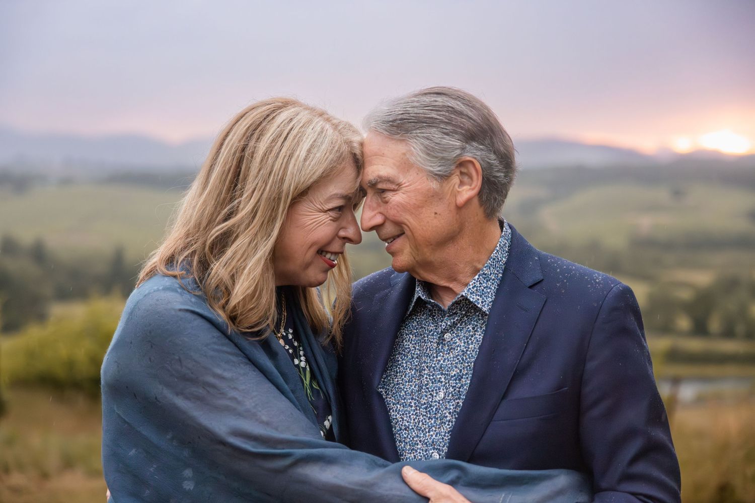 Tender moment captured at sunset with rolling hills in background.
