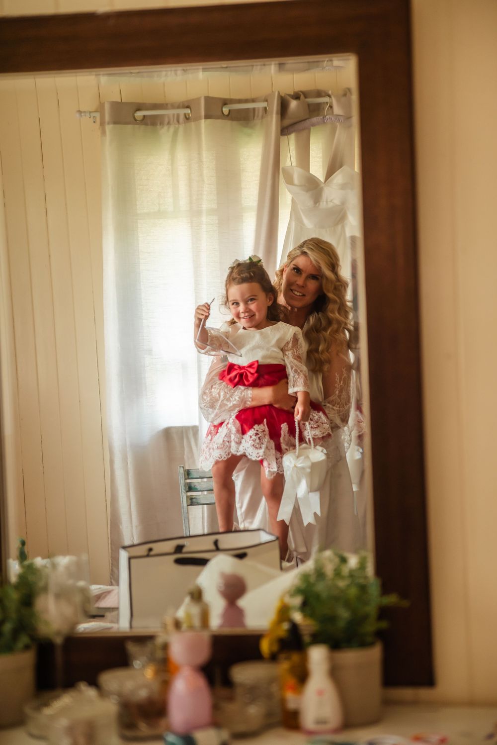 Playful moment reflected in mirror during wedding preparations.