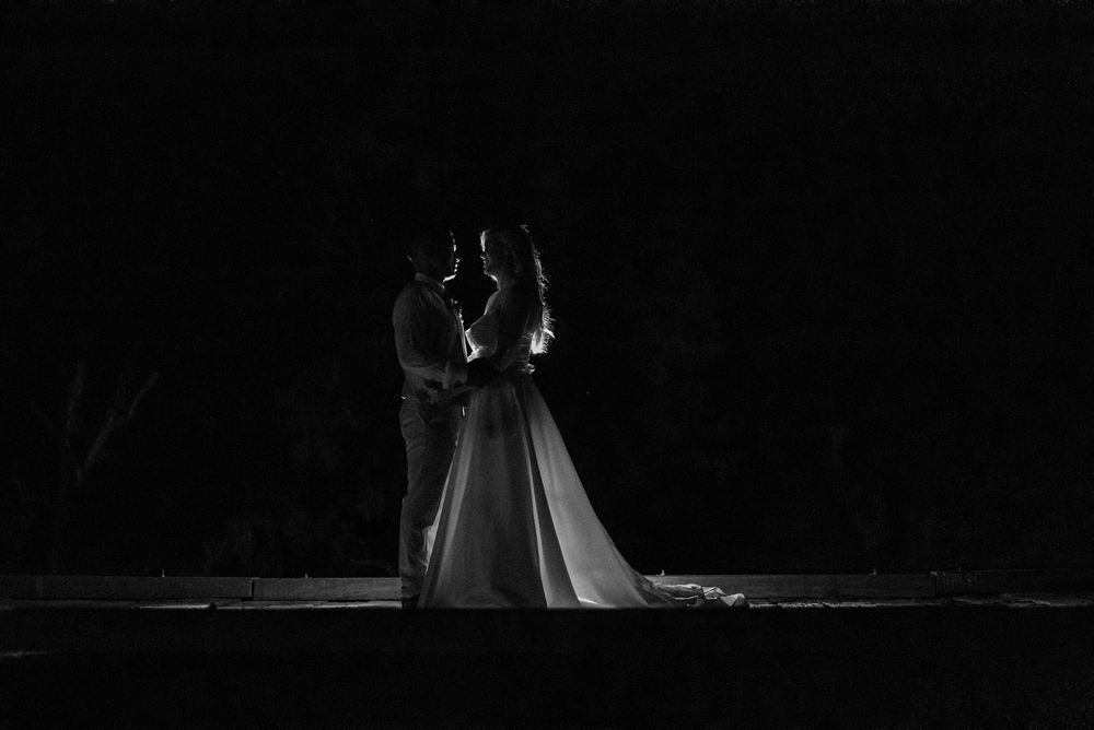 Dramatic silhouette of a couple dancing at their wedding reception.