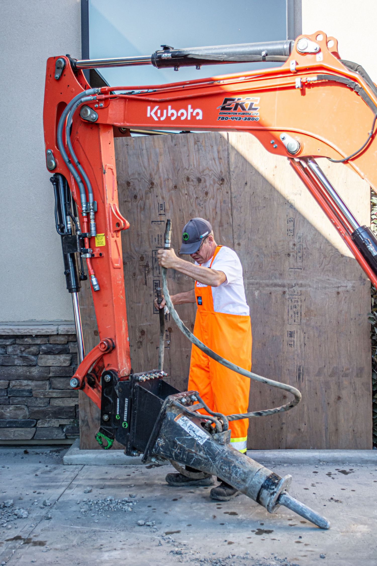 Industrial photographer in high-visibility vest documenting heavy machinery in action.