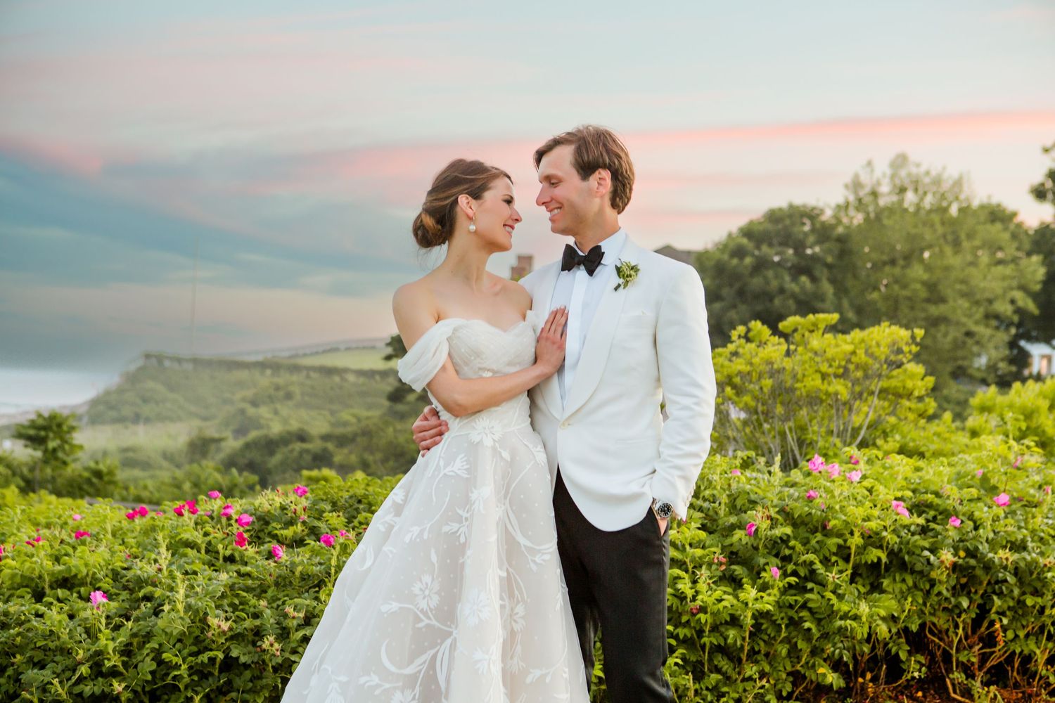Romantic sunset portrait in a garden overlooking a scenic landscape.