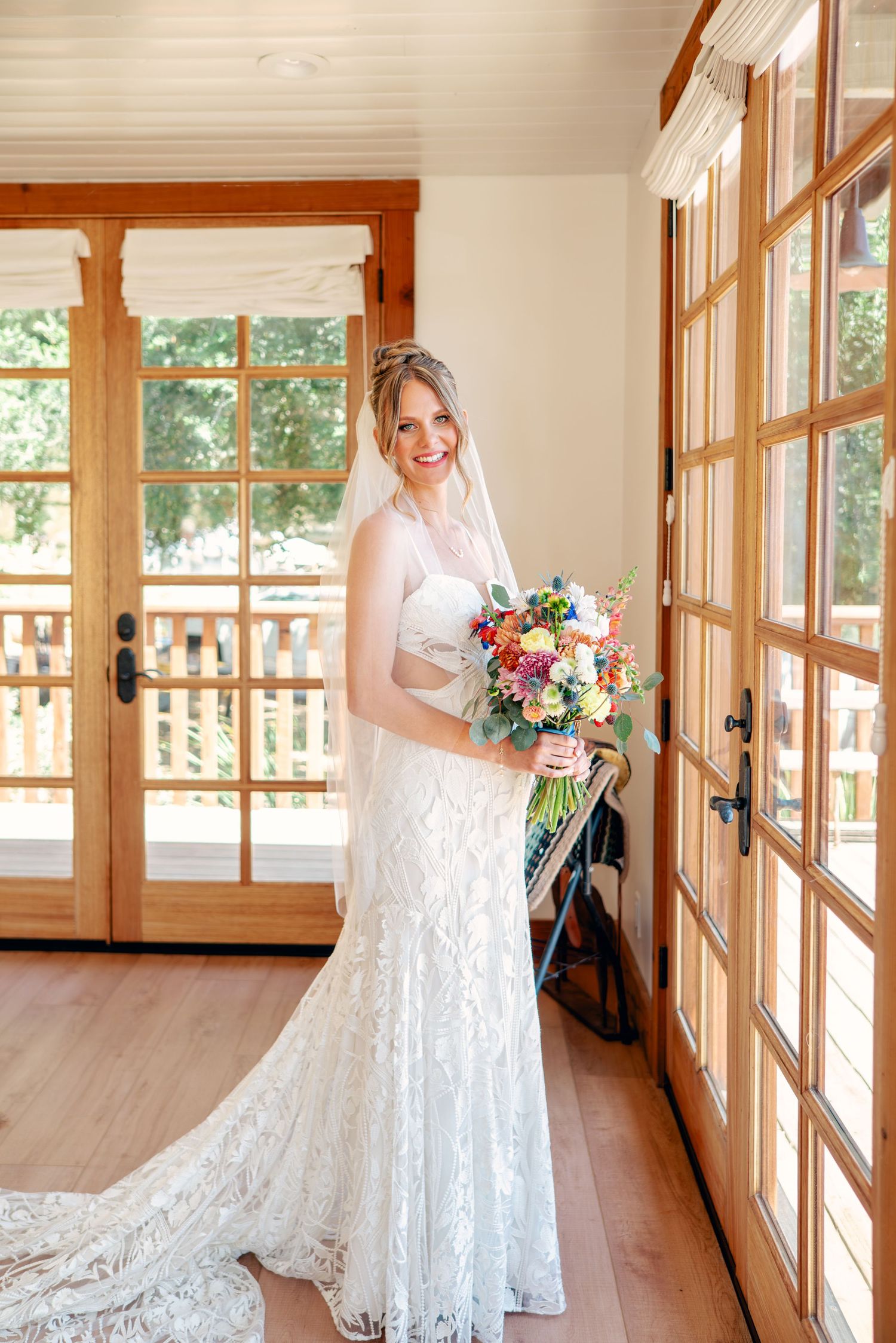Wedding preparations in a sunlit room with wooden trim and large windows.