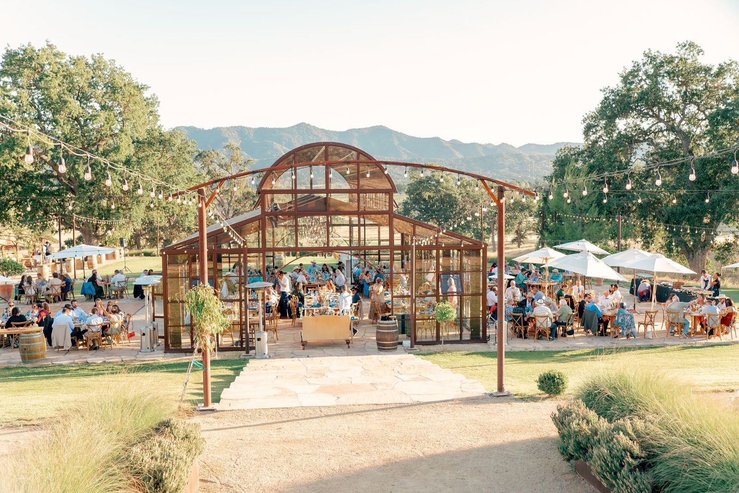Greenhouse wedding venue with mountain views and outdoor seating area.