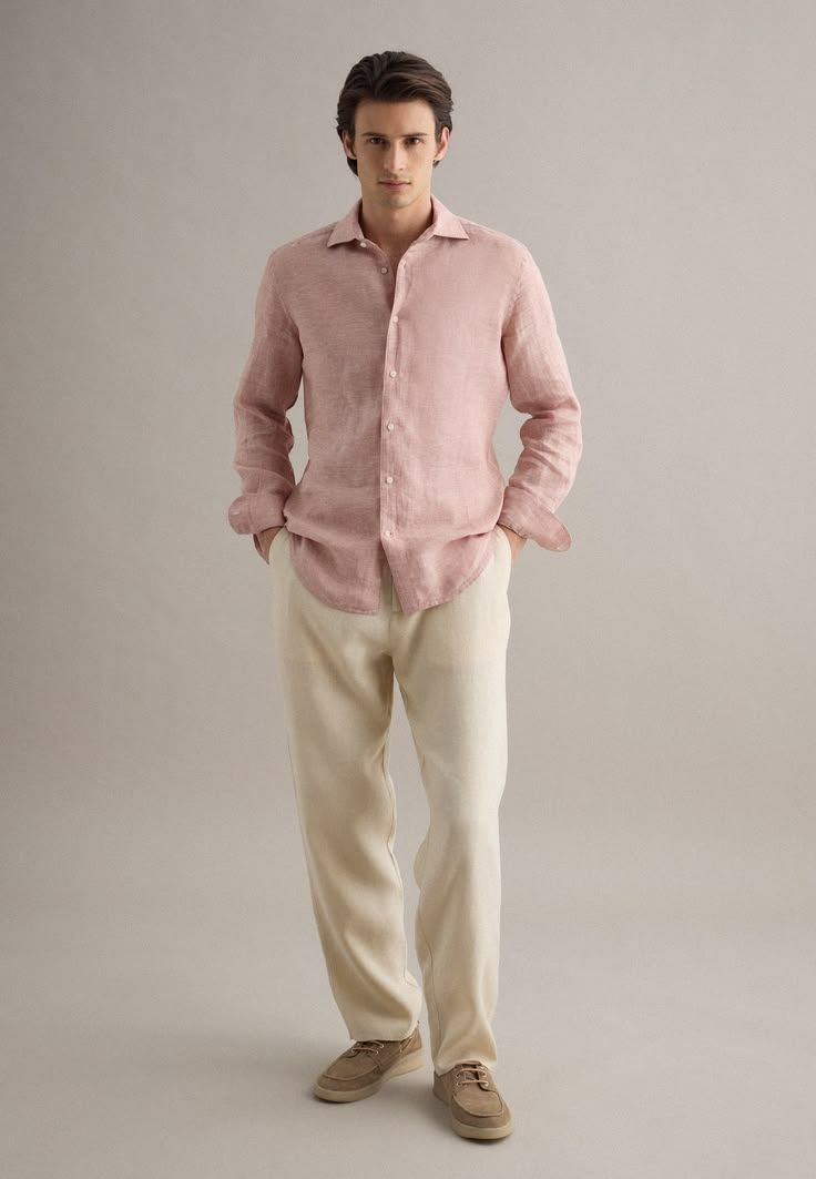Man wearing a pink linen shirt with cream wide-leg trousers and beige loafers on a neutral background.