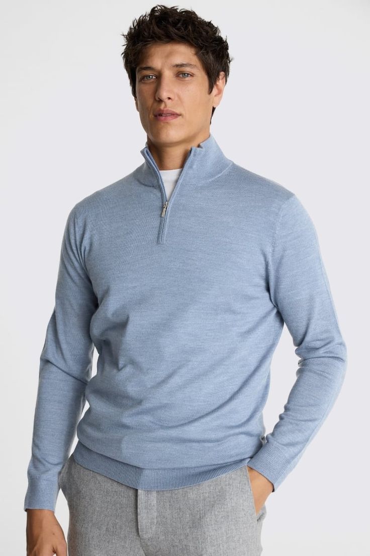 Man wearing a light blue merino wool quarter-zip sweater with a smooth knit, paired with grey trousers.