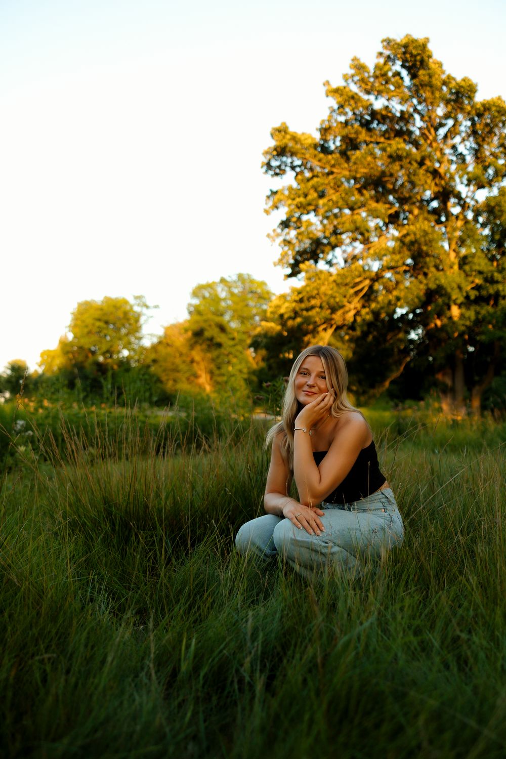 A series of outdoor portraits in tall grass at golden hour with trees in the background.