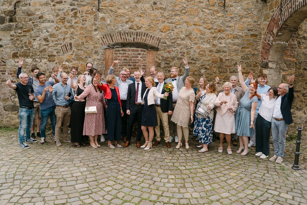 Gruppenbild der Hochzeitsgesellschaft im Innenhof der Welschen Mühle in Aachen Haaren nach der standesamtliche Hochzeit.