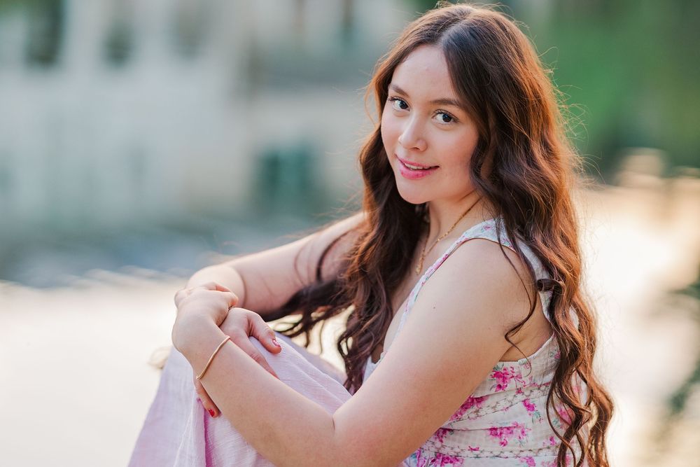 A dreamy outdoor portrait session in a floral dress near water during golden hour.