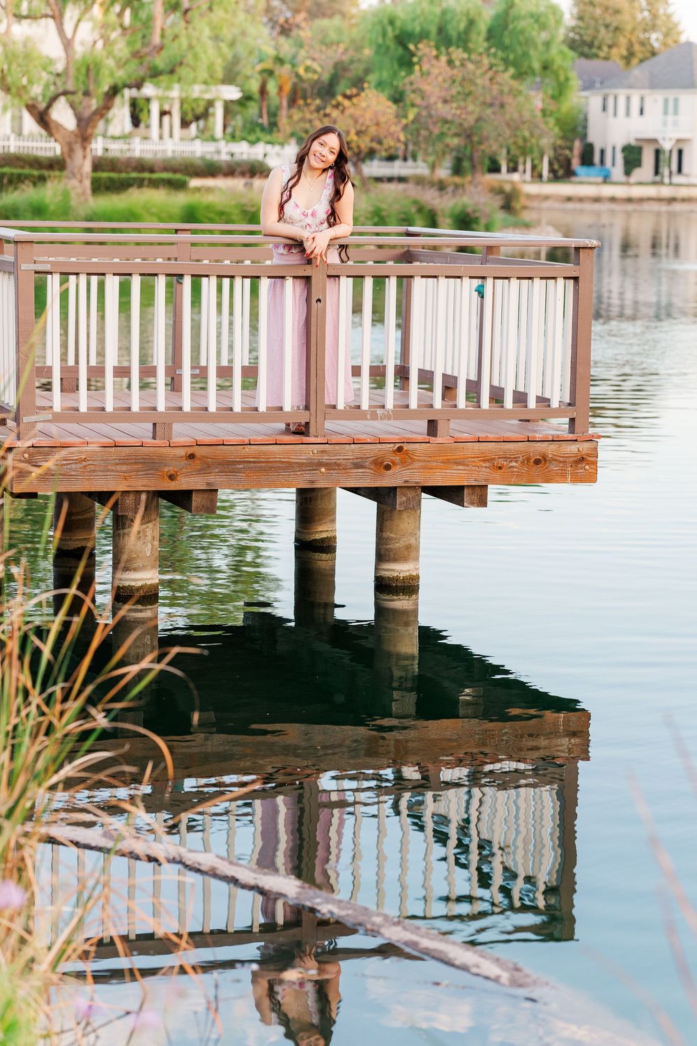 A tranquil scene at a lakeside dock with reflections in the water during golden hour.