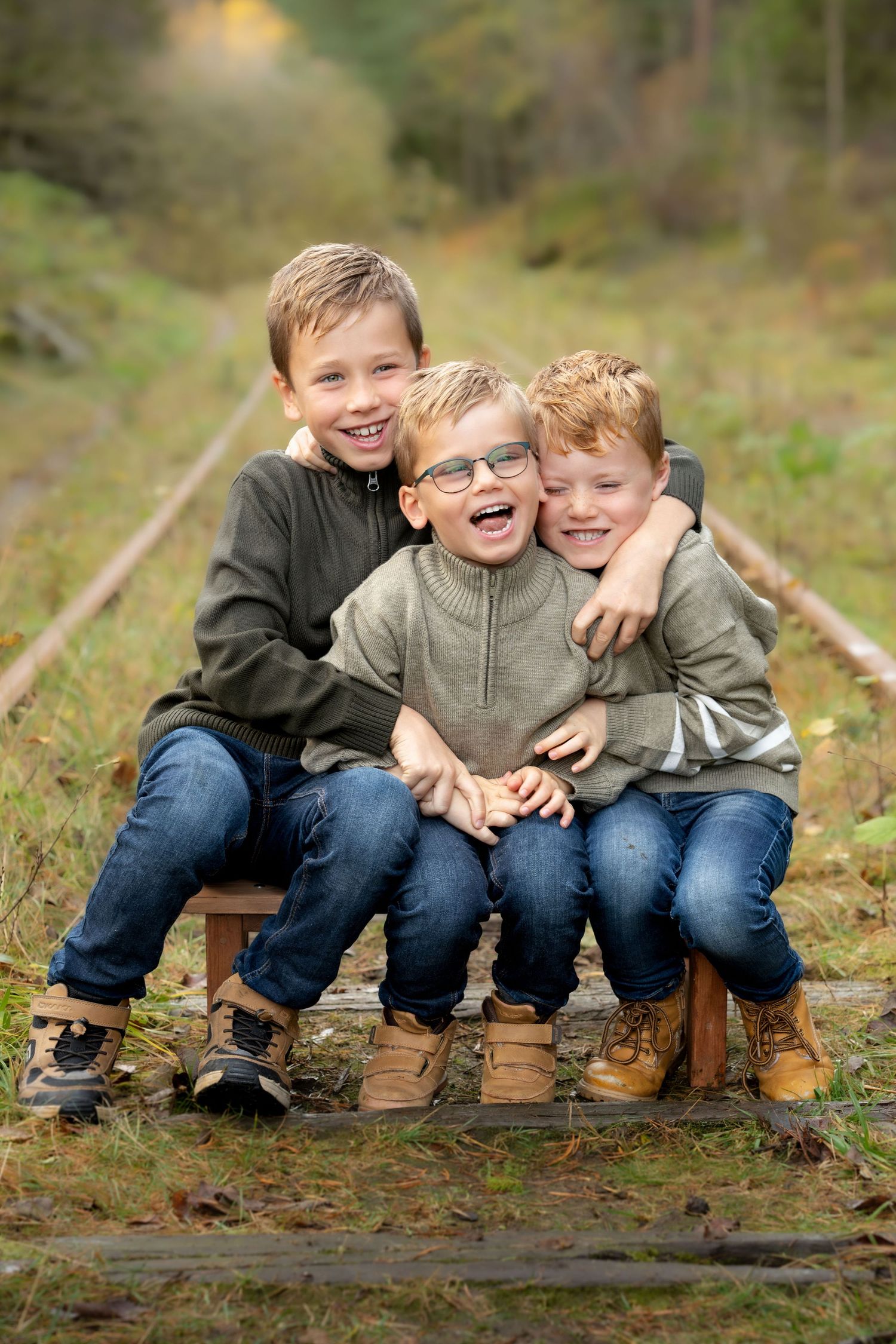 Familiefotografering i Sandnes, tre brødre holder rundt hverandre og ler