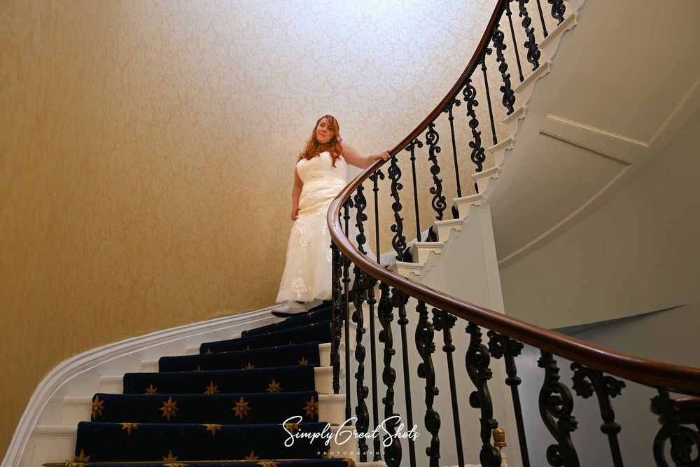 A beautiful bride (Hailey) walks down the spiral staircase at Eastwood Manor