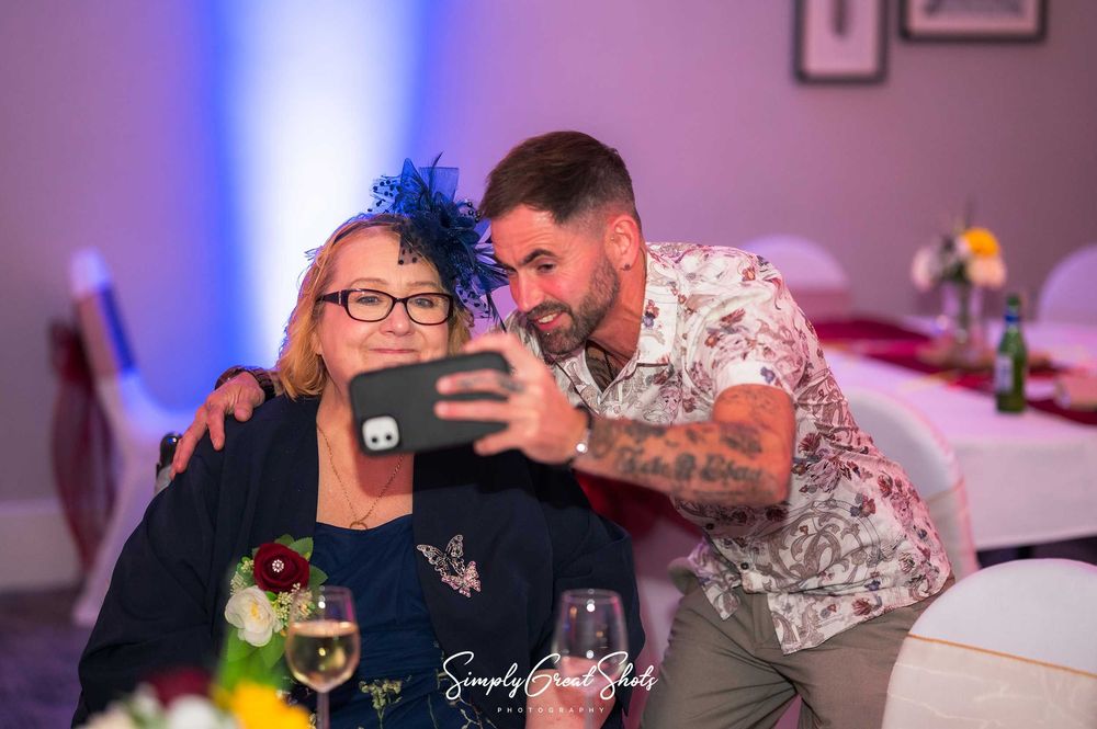 Eastwood Hall wedding photographer captures the mother-of-the-bride posing for a selfie with her son.