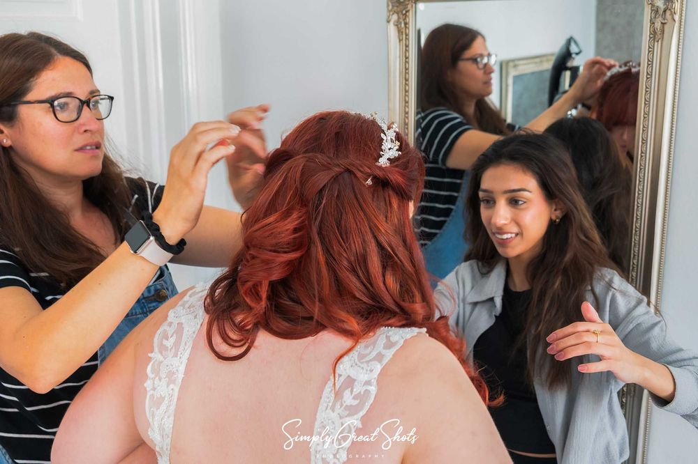 Bridal preparations underway with the bride, a hair dresser and a make up artist all busy at work at Eastwood Hall wedding venue.