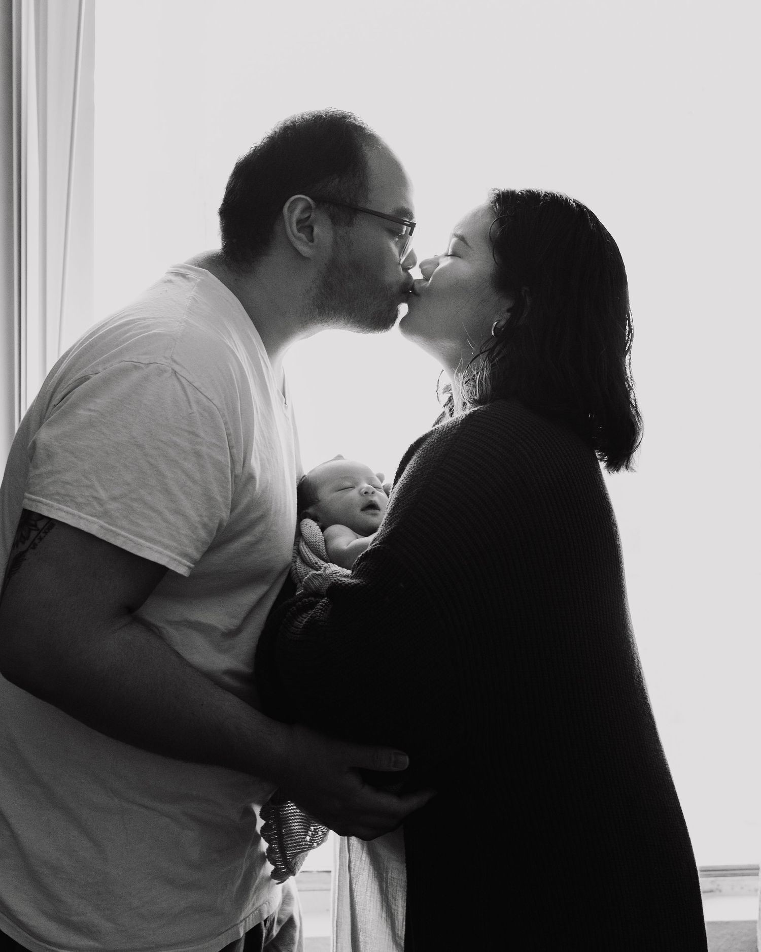A romantic black and white silhouette sequence showing an intimate moment between two people by a window.
