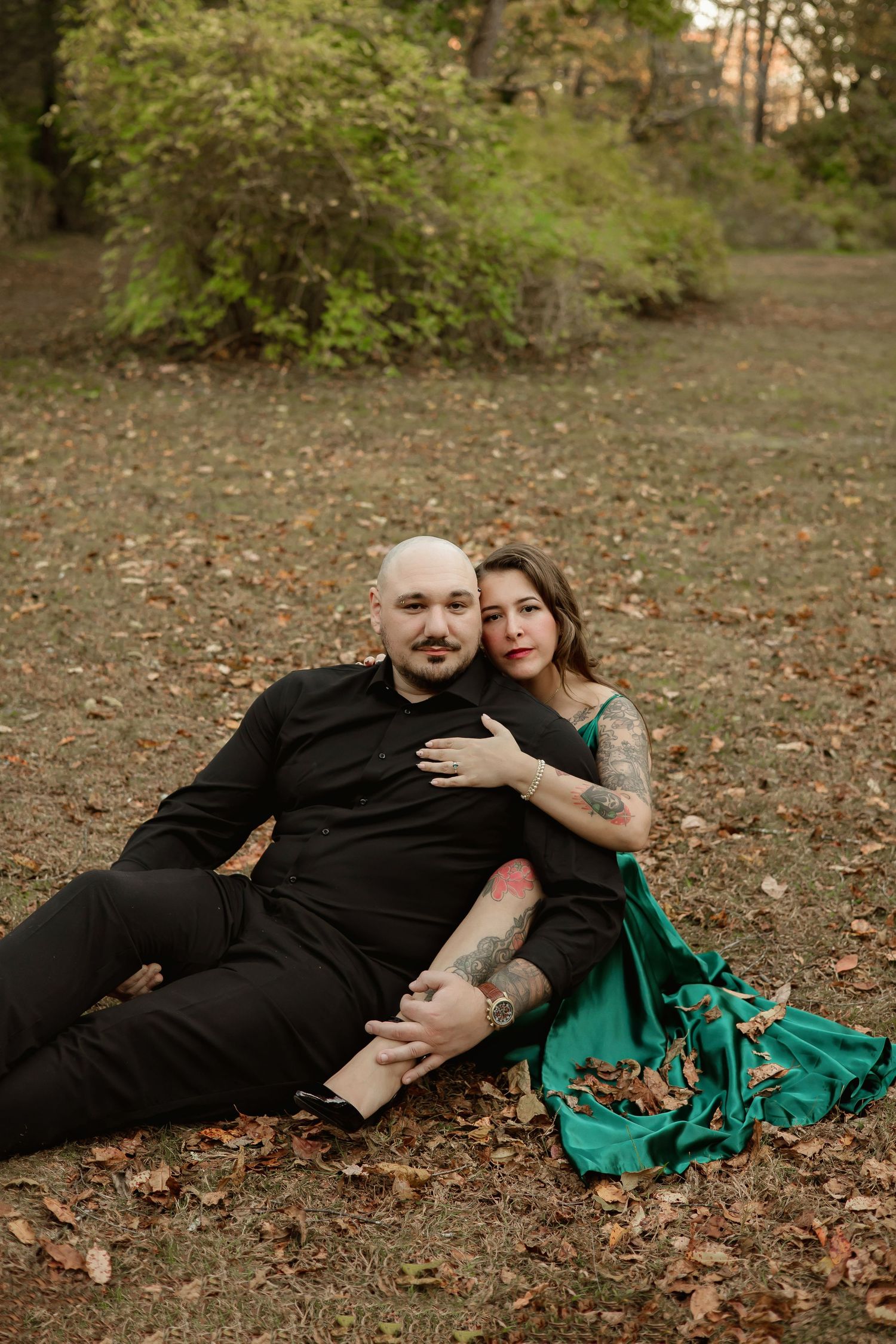 A romantic proposal scene set between rows of grapevines in a scenic vineyard with white flowers and a blanket.