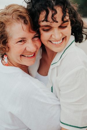 Close-up series of a joyful couple laughing and embracing in white clothing against a dark background.