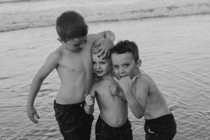 Group of children playing together by the water in black and white.