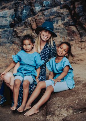 A group sits together on rocky terrain, wearing coordinated blue outfits.