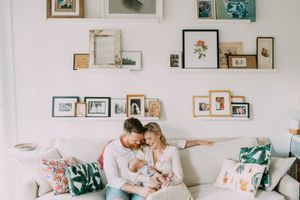 A cozy living room scene with family photos displayed on floating shelves above a white sofa.