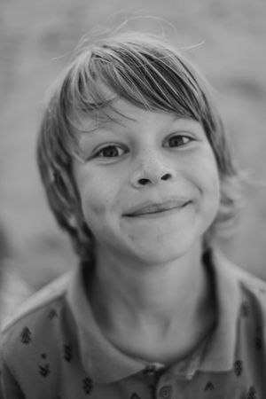 A black and white portrait showing a gentle smile and windswept hair.