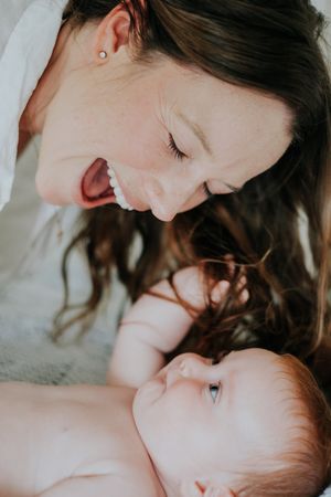 Close-up tender moment between parent and baby in soft natural light.