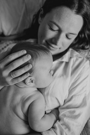 Intimate black and white portrait of parent and newborn bonding.