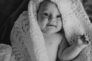 Black and white portrait series of a baby wrapped in delicate lace.
