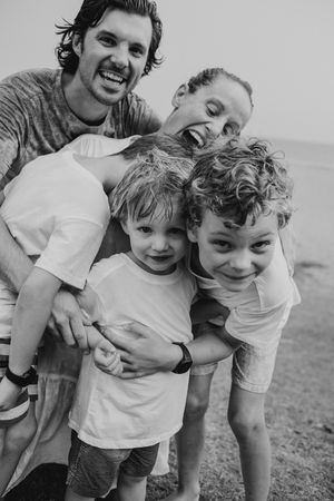 Candid black and white photo showing playful interaction between family members.