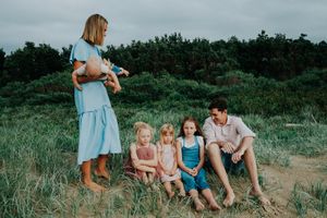 Family spending quality time together on a grassy coastal hillside.